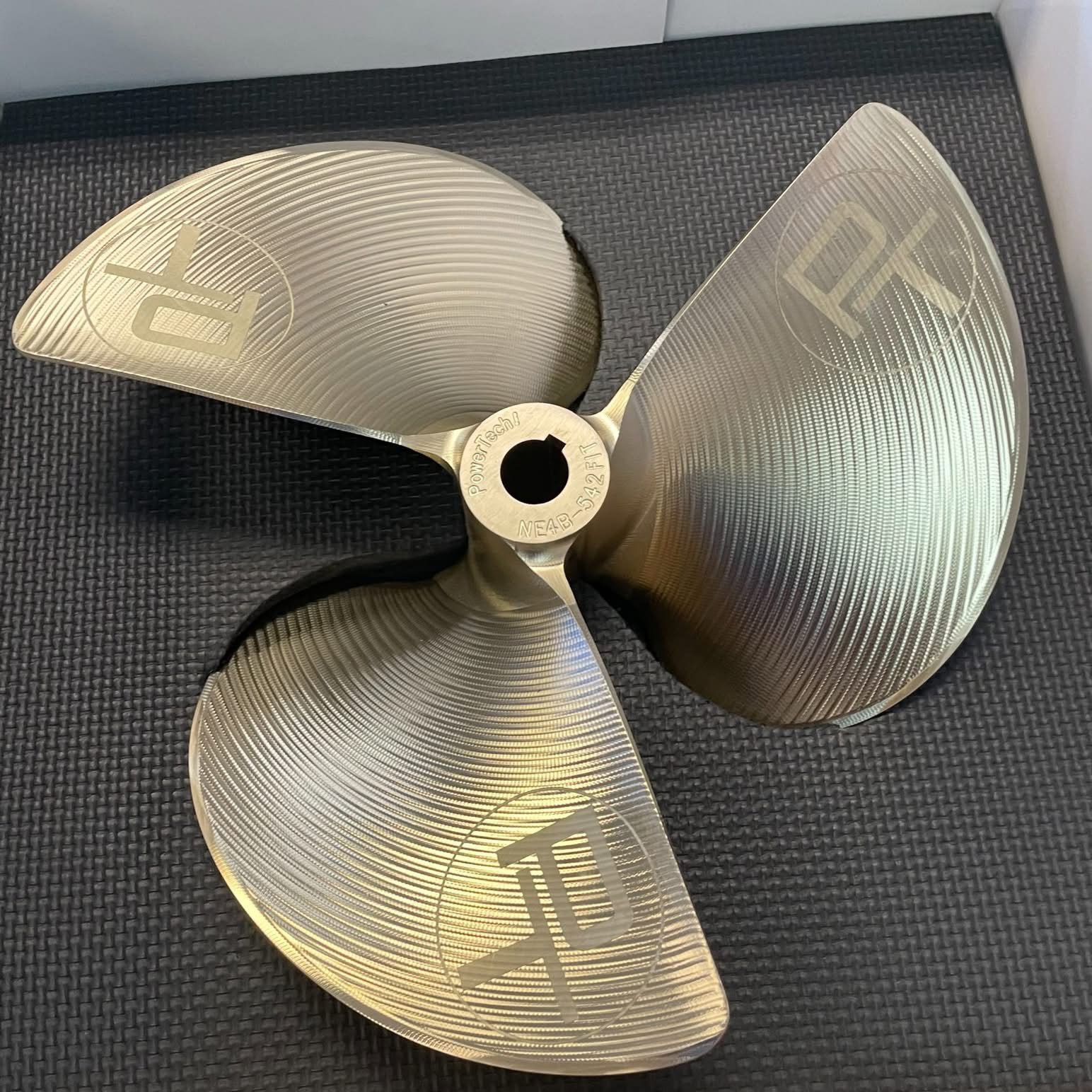 Close-up of a bronze ship propeller with three blades.